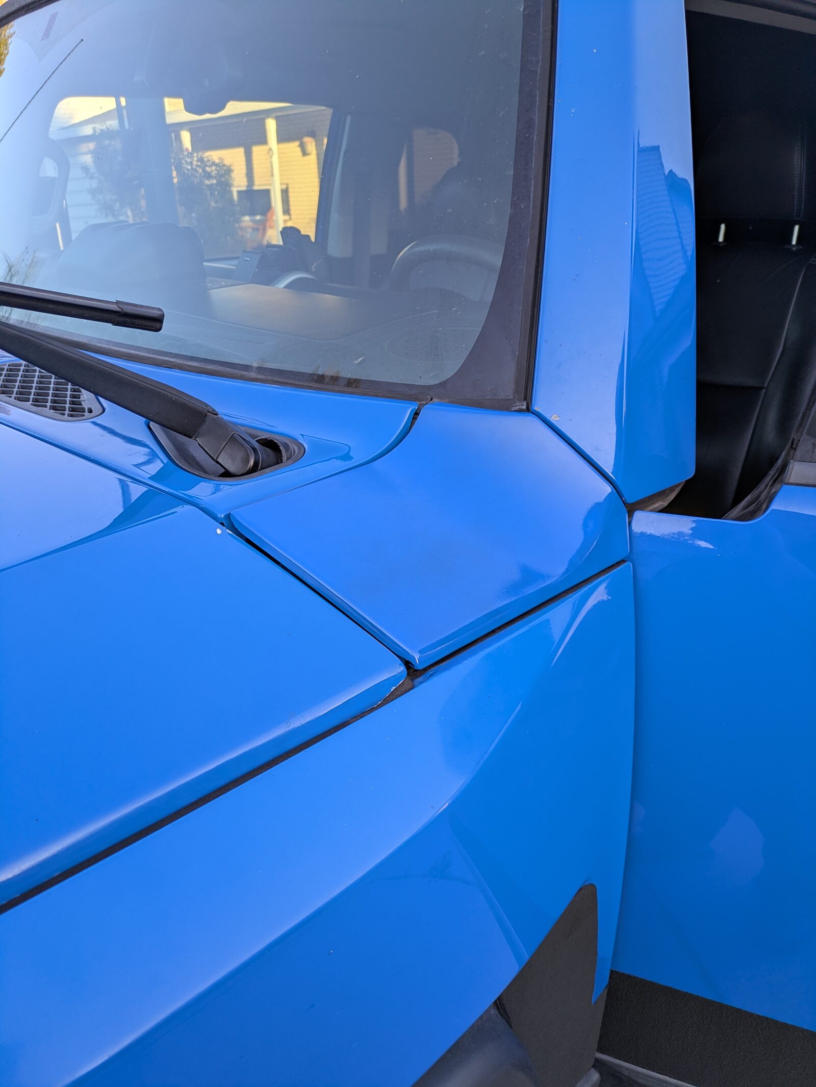 The repainted Voodoo Blue cowl panel back in place at the base of the FJ's windshield